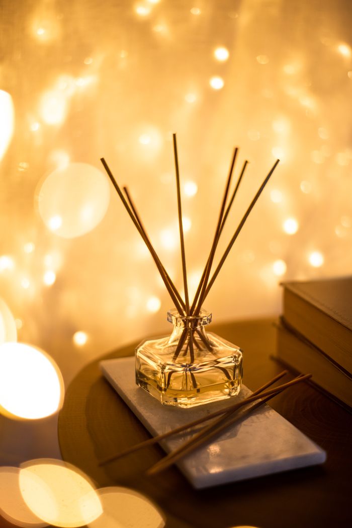 Negozio A decorative reed diffuser with a bokeh light background, creating a warm atmosphere.