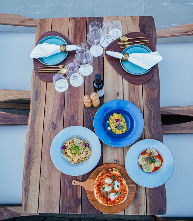 pexels photo 16018408 16018408 Top view of a rustic table set with Italian and Mediterranean dishes for a delightful outdoor meal.